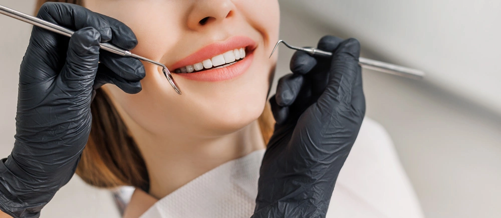 Close-up of female smile with white teeth during medical examination.