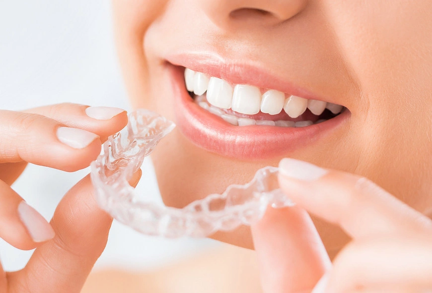 Woman wearing orthodontic silicone trainer. Invisible braces aligner.