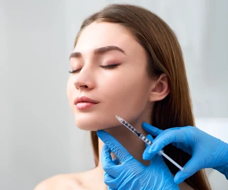 Smile lifting and lip augmentation. Beautician doctor hands doing beauty procedure to female face with syringe.