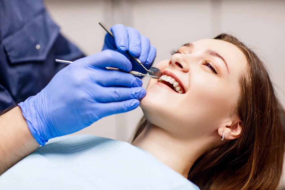 Dentist check-up teeth to young woman patient in clinic.