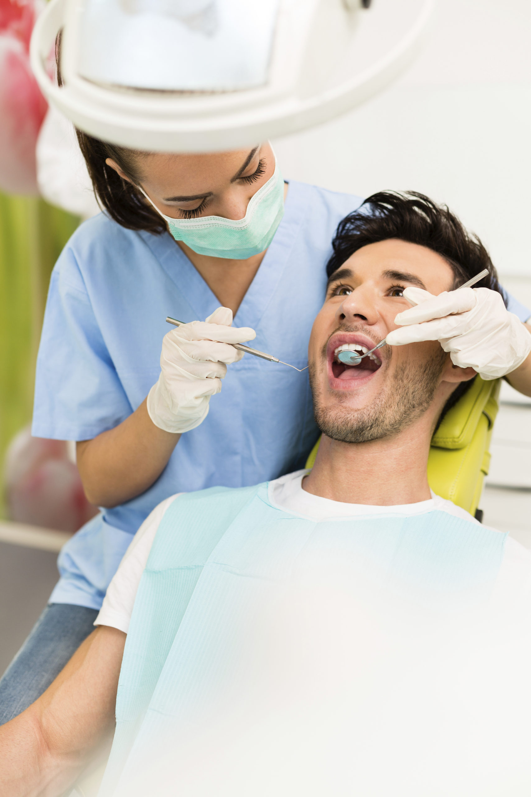 Dentist checking man's teeth