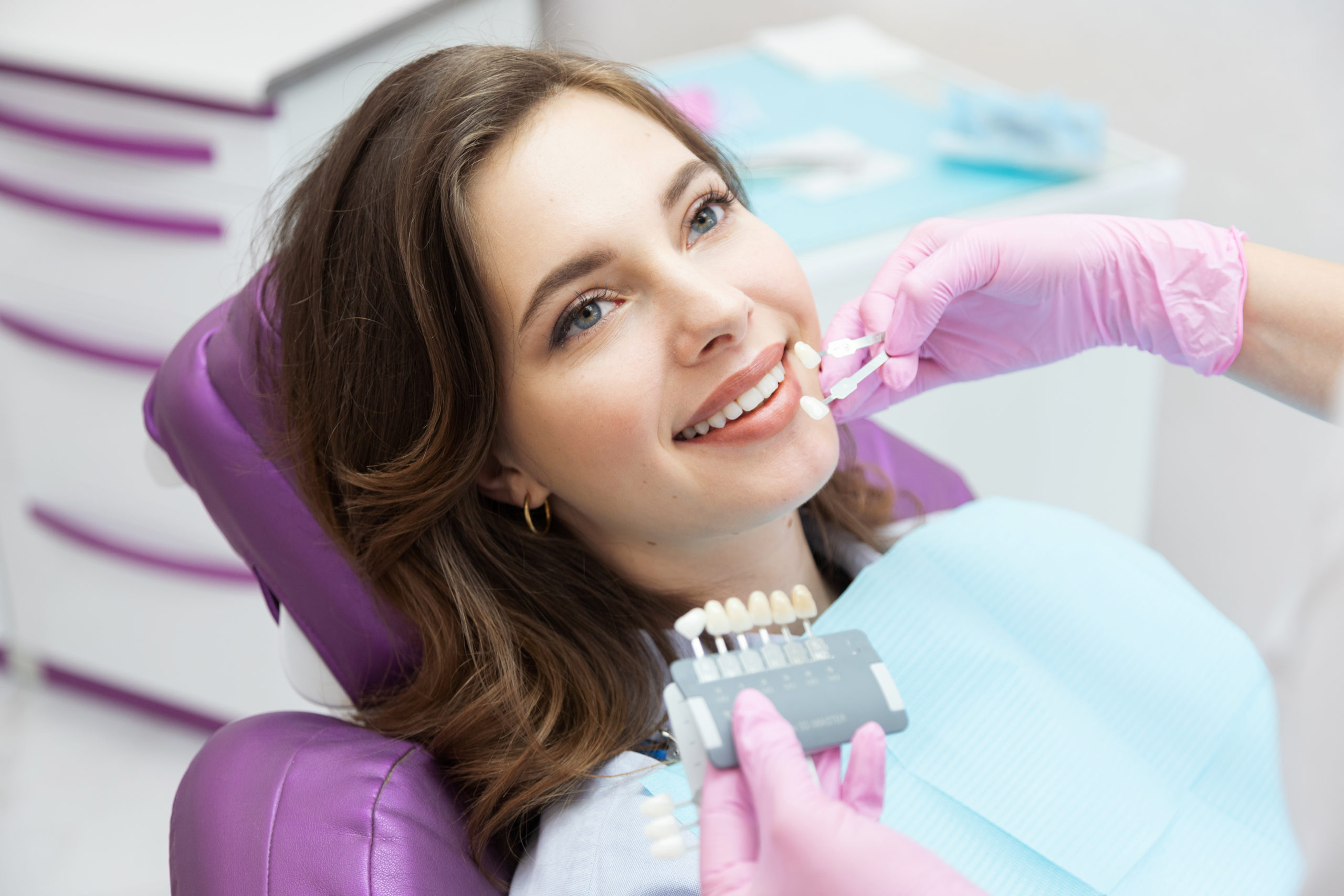 Dentist choosing teeth enamel shade color for woman